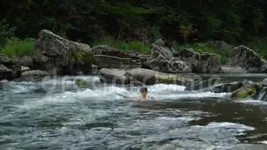 女人在<strong>河里</strong>洗澡。 一个年轻漂亮的女人沐浴在干净的山<strong>河里</strong>。 她很开心。