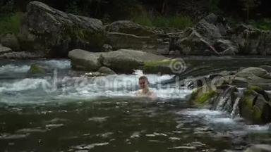 女人在河里洗澡。 一个年轻漂亮的女人沐浴在干净的山河里。 她很开心。