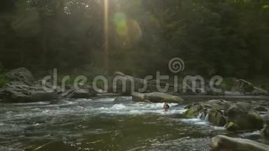 女人在河里洗澡。 一个年轻漂亮的女人沐浴在干净的山河里。 她很开心。