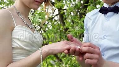 新郎在春天的花园里穿新娘结婚戒指