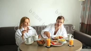 年轻夫妇在<strong>酒店</strong>房间的沙发上吃<strong>早餐</strong>