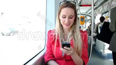 年轻的金发女郎骑着电车，在<strong>手机</strong>、<strong>手机</strong>、<strong>手机</strong>上打字，微笑着