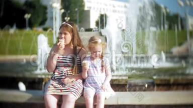 儿童，小女孩在炎热、炎热的夏日吃冰淇淋，孩子们在喷泉附近