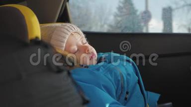 幼儿男孩在汽车上睡在儿童安全座椅上。