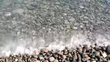 沙滩上的小浪在卵石中破碎