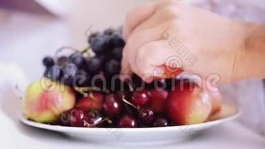 人类`用葡萄樱桃和桃子从盘子里拿水果。 1920x1080。 <strong>高清高清</strong>