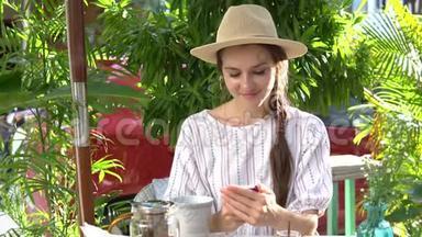 女人一边喝茶一边用手机。