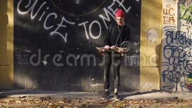 在涂鸦墙前玩滑板的青少年