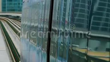 地铁列车在阿联酋迪拜的玻璃摩天大楼间穿梭
