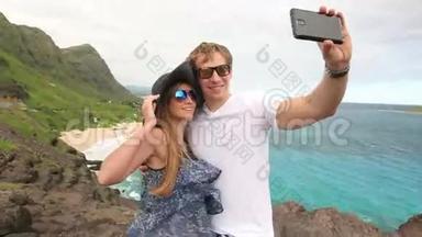 在夏威夷、瓦胡岛、马卡布乌岛，微笑年轻夫妇游客用相机手机拍摄自我肖像