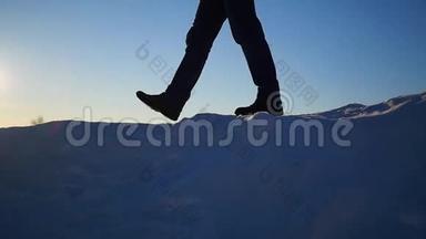 这家伙在一个雪坡上，在日落时举起双手。下雪的冬天风景。 户外运动