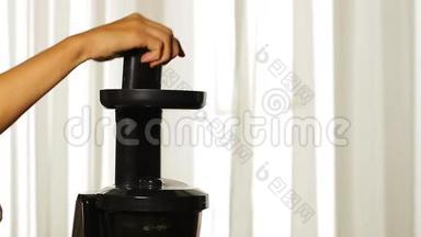 女人的手在榨汁机里加入芹菜。
