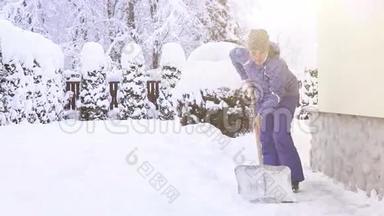 在大雪后，年轻女子在房子附近铲雪