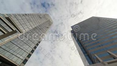 超高清4k时间推移电影，白色移动云在市中心高玻璃大厦与反射