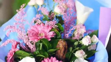 特写，花束在光线的照射下，旋转，花的组成由粉红色的格伯拉、变形金刚、卡拉组成