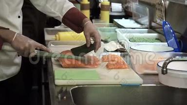 <strong>寿司</strong>卷三文鱼的<strong>制作</strong>和切割过程。 用刀子把鱼切成薄片.