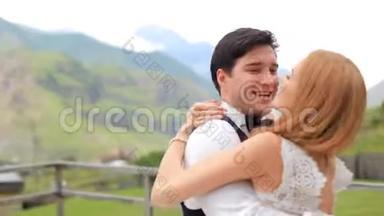 结婚纪念日。 幸福的新婚夫妇在群山的背景下玩得很开心。