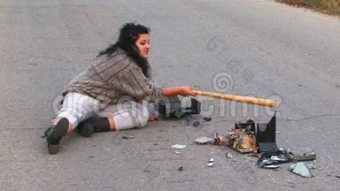 疯狂的女人在车道上对着破碎的<strong>电视机</strong>说话