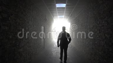 隧道尽头的灯光。 那个人进入了光明。 一条走廊，尽头有明亮的灯光。