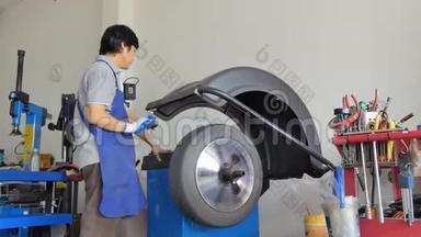 亚洲技术人员<strong>正在修理</strong>车库里的轮胎.