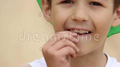 男孩在镜头前摇动一颗婴儿牙齿，把婴儿牙齿贴紧