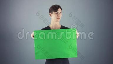 年轻男子身<strong>穿</strong>黑色衬衫，手持绿色钥匙片<strong>海报</strong>，灰色背景