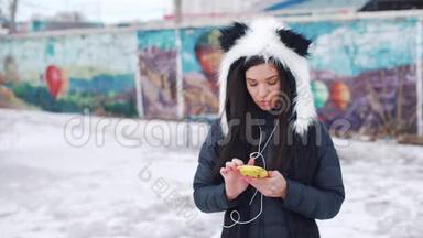 一个戴着熊猫帽的女孩在城里听音乐