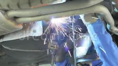 机械师切断汽车里的<strong>消声器</strong>。