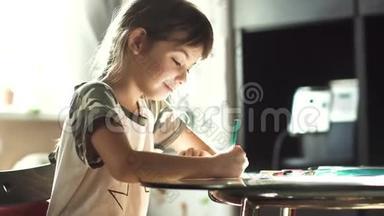 小女孩在家里用<strong>铅笔画画</strong>，坐在桌子旁。 在朝阳下的孩子