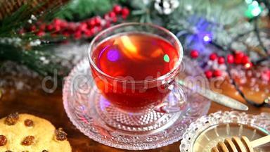 <strong>冬</strong>茶一杯带蜂<strong>蜜</strong>、牛角面包或饼干的茶，雪中圣诞树的一根树枝，圣诞灯
