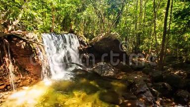 热带森林中的小瀑布落入透明池塘