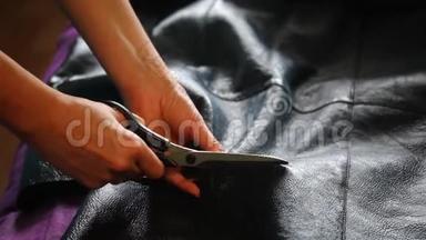 那个女人正在剪羊皮大衣。 他用一件羊皮大衣把羊皮剪了，然后把它铺开。