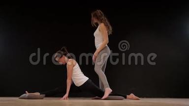 瑜伽教练帮助学生伸展肩膀。 快<strong>乐运动</strong>适合女孩