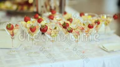 在一张白色桌子上放着草莓的玻璃杯里的<strong>水果</strong>。 庆祝<strong>活动</strong>。