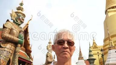 视频亚洲高级男子访问瓦特拉卡尤，翡翠佛寺地标曼谷，泰国