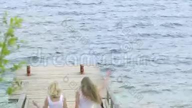 两个朋友女人用手机在河边自拍。 两个小女孩在河边玩耍，自拍