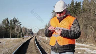 铁路工程师在铁路上与平板电脑合作