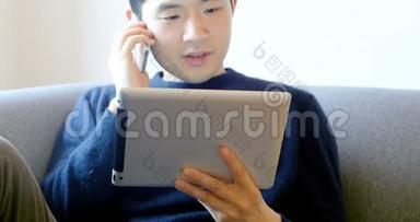 男子在客厅4k使用数码平板电脑时使用手机
