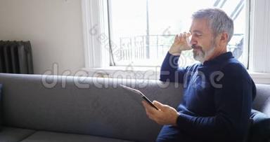 男子在客厅4k使用数码平板电脑时使用手机