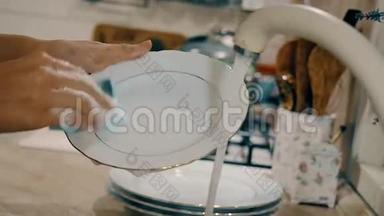 女人正在厨房里用肥皂洗碗。 带有侧面<strong>摄像机运动</strong>的特写镜头