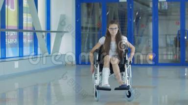一个坐轮椅的年轻女孩站在医院的走廊里。