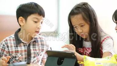 一群小亚洲孩子吃零食，一起玩电脑平板电脑。
