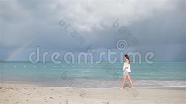 热带海滨的年轻美女。 快乐女孩的背景是蔚蓝的天空和碧蓝的海水