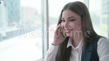 一个女商人坐在咖啡馆里微笑着打电话