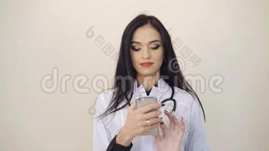 漂亮的女医生在后台使用手机。 4K
