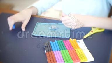坐在桌子旁的女孩，从彩色模型塑料中<strong>画出</strong>不同的<strong>图</strong>形。 艺术造型的发展