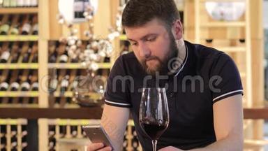 一个年轻人在喝<strong>红酒</strong>时使用智能手机，一个孤独的男人拿着<strong>一杯红酒</strong>，一个穿着一件衣服的年轻人