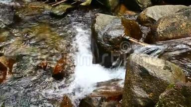 自然视频，森林中的一个小瀑布.. 雨后，水流穿过岩石。 隐藏在森林中的瀑布