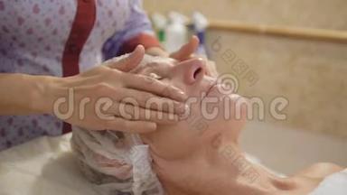 中年妇女在spa沙龙接受面颈部淋巴引流按摩