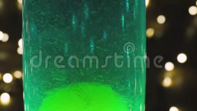 熔岩灯复古嬉皮抽象背景，绿色蜡移动漂浮。 背景中花环的波克